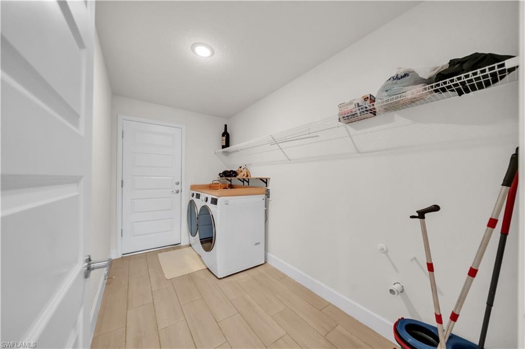Laundry area with wood-finish flooring, recessed lighting, and a solid-panel door