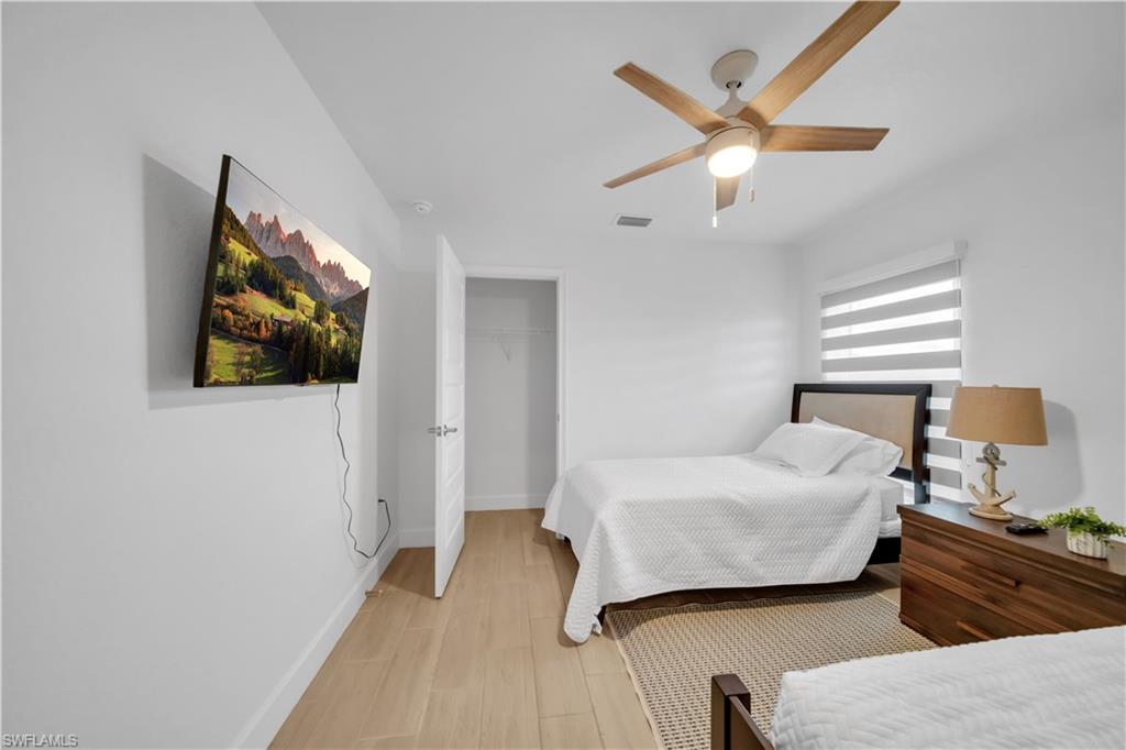 Recessed lighting, wood-finish flooring, ceiling fan, window with horizontal blinds, and a built-in closet