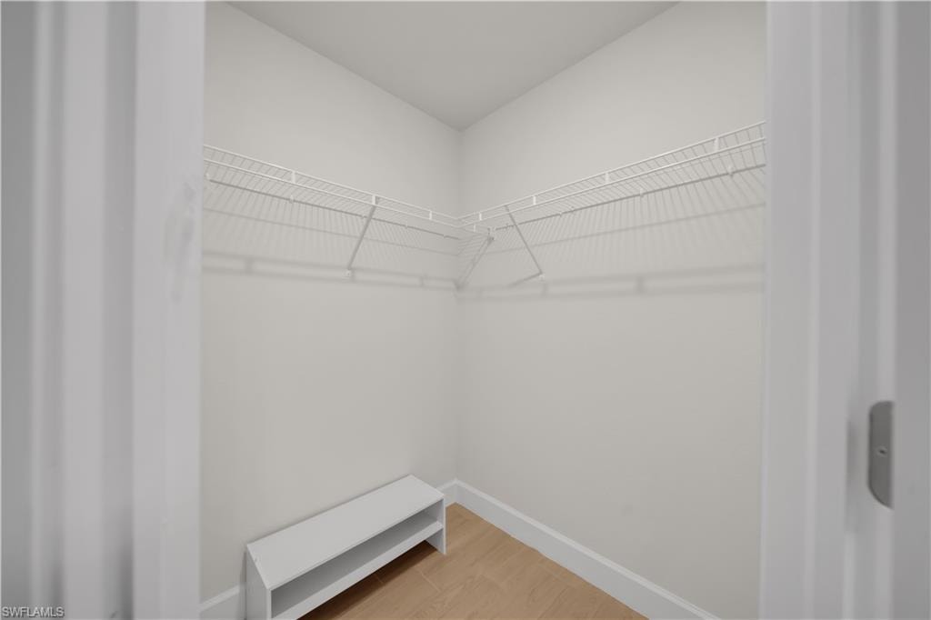 Spacious closet featuring wire shelving, wood-finish flooring, and a built-in shoe rack