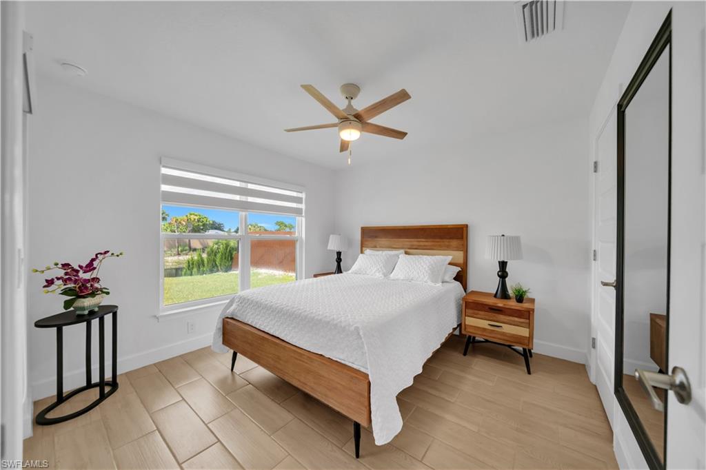 White walls and wood-finish flooring complement the window with outdoor views