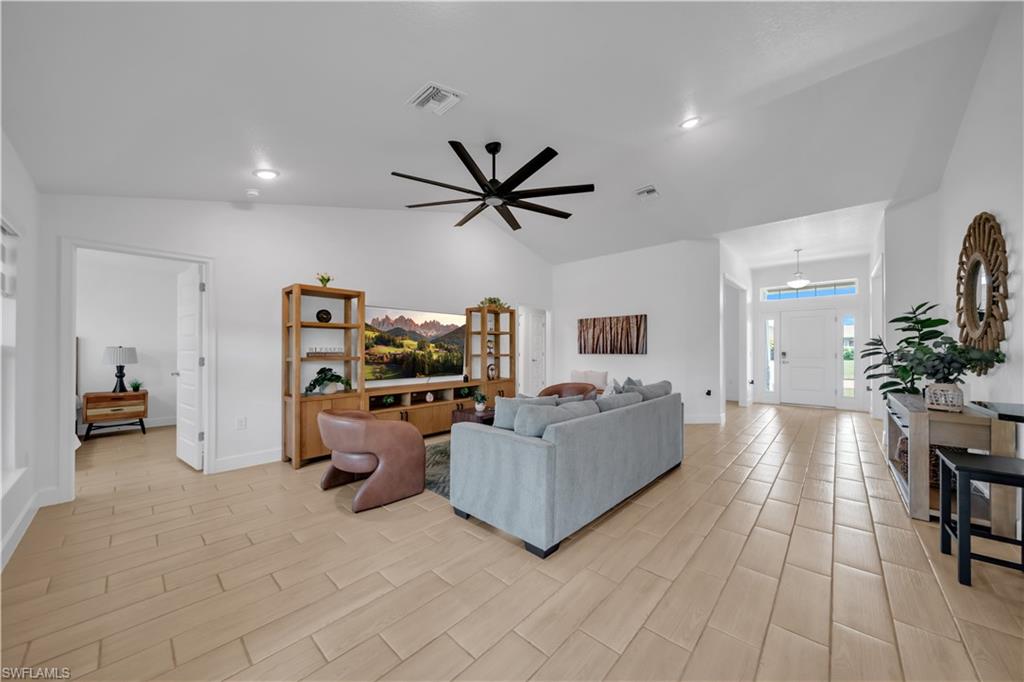 Vaulted ceilings, plank-style tile flooring, and a modern ceiling fan
