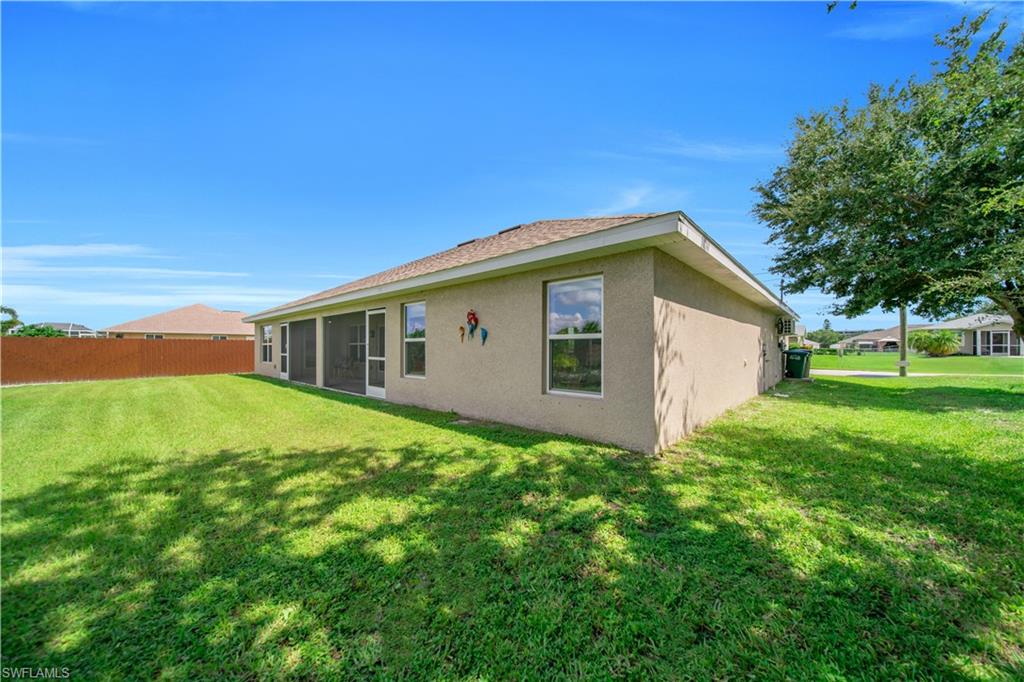 Expansive green space with a wood privacy fence, screened patio, and mature landscaping
