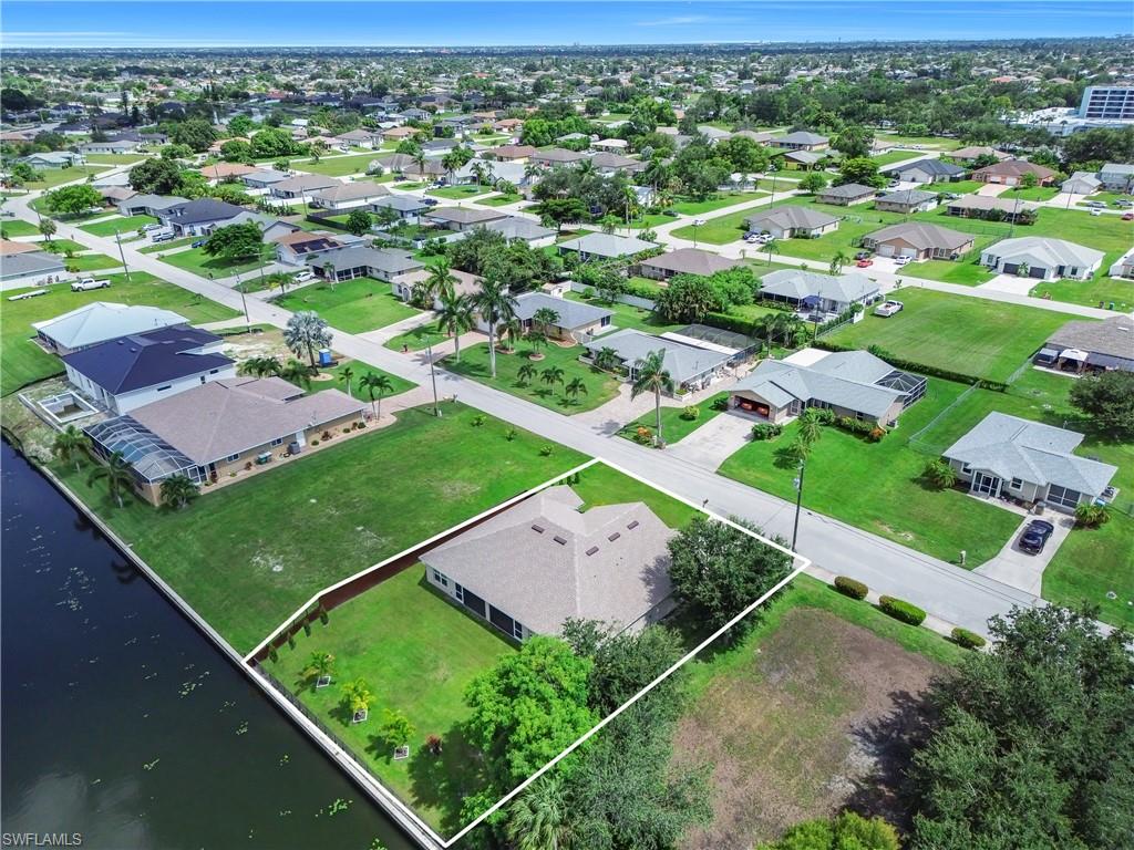 Waterfront property with direct canal access, expansive green space, and mature landscaping