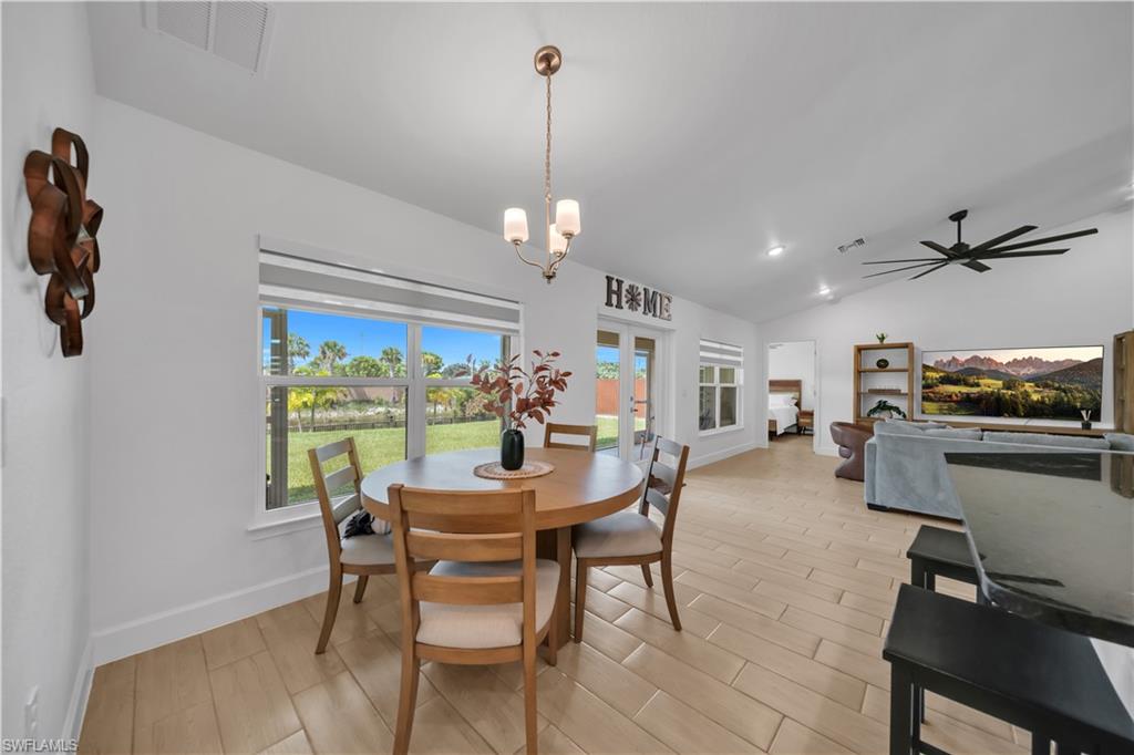 Vaulted ceilings with recessed lighting, an open-concept layout, and light wood-finish tile flooring