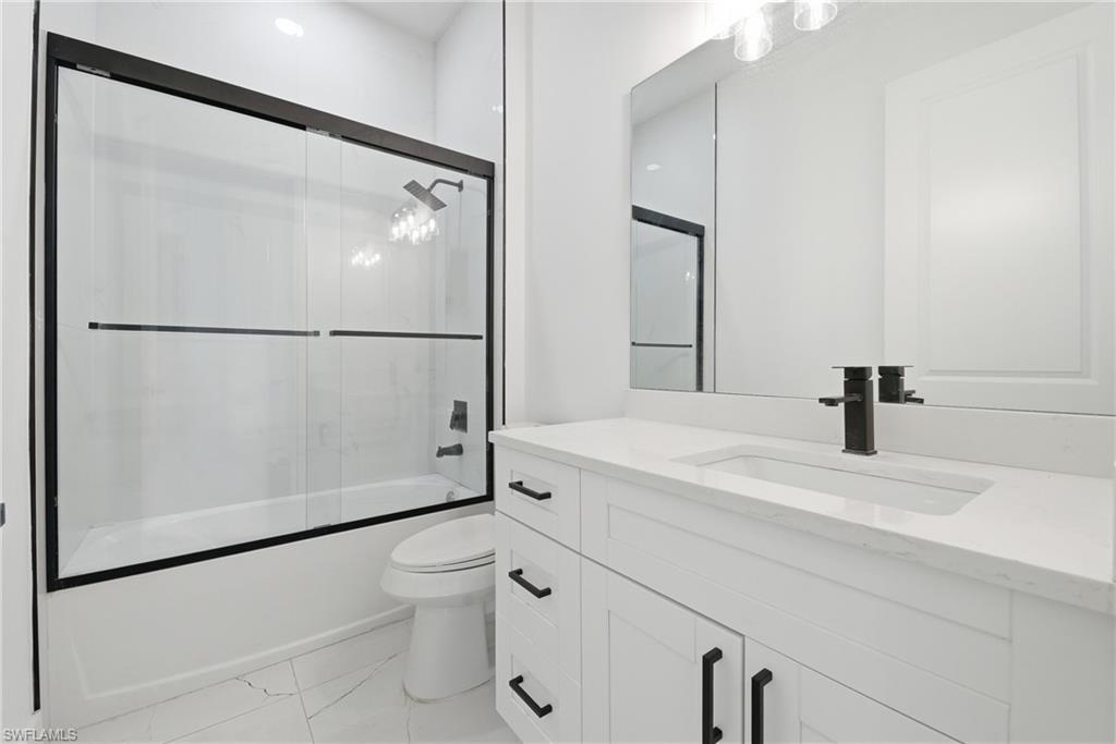 White vanity with black hardware, integrated rectangular sink, and single-handle faucet