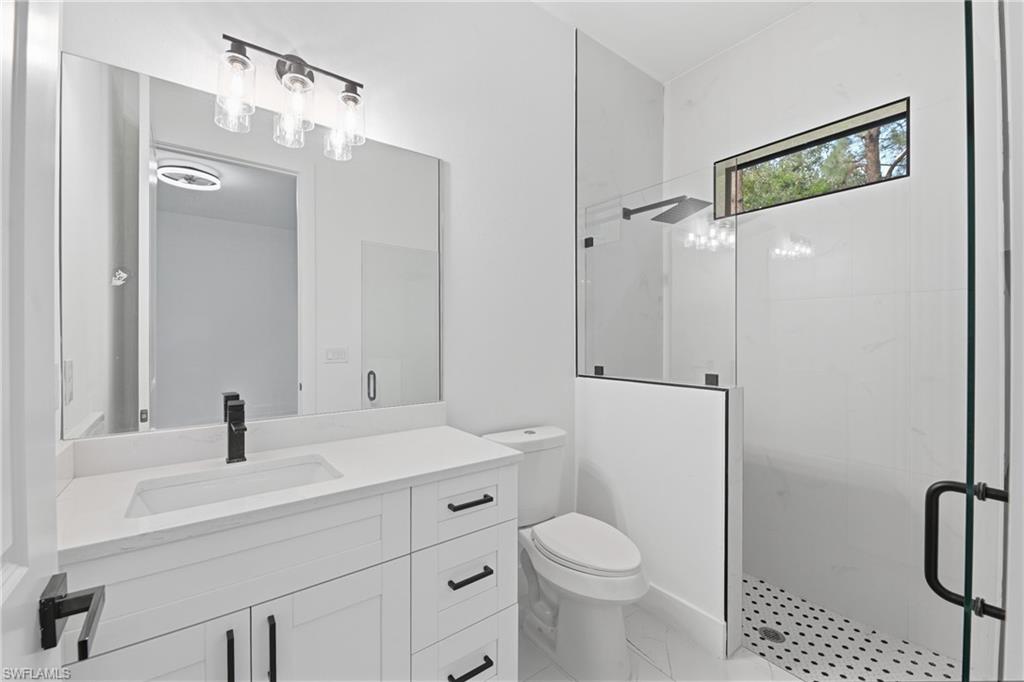 White vanity with quartz countertop, undermount sink, and matte black fixtures