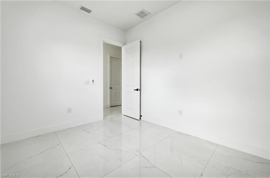 White interior walls with a matte finish, white trim, and large format tile flooring
