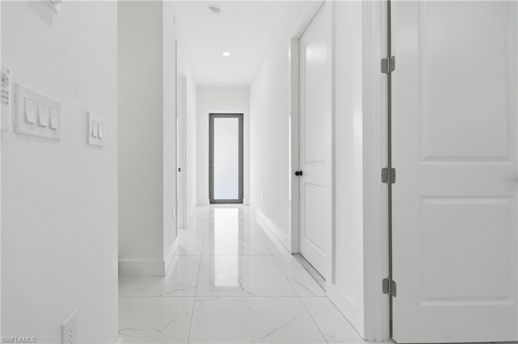 White panel doors, recessed lighting, and white tile flooring