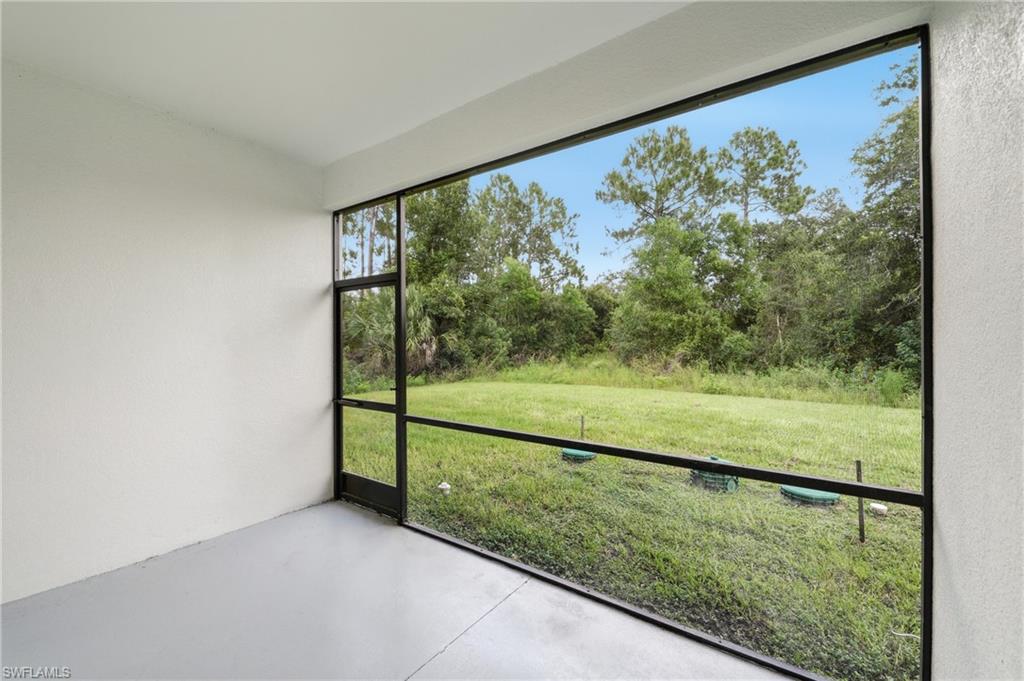 Screened outdoor area with concrete flooring, framed by a natural landscape
