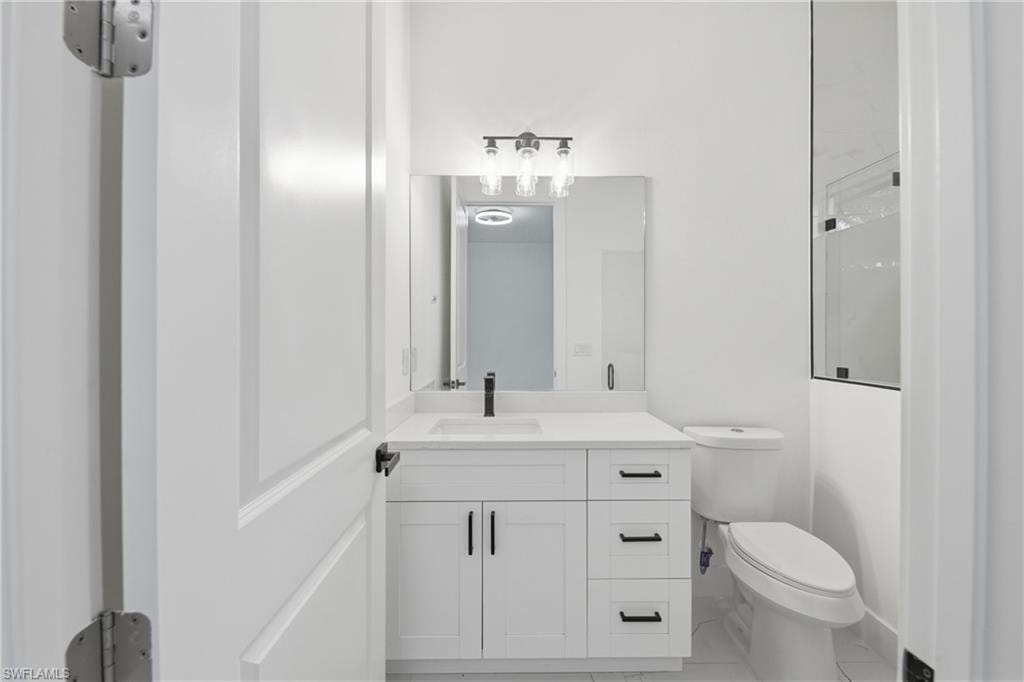 White vanity with a single basin, single-handle matte black faucet, and white countertop