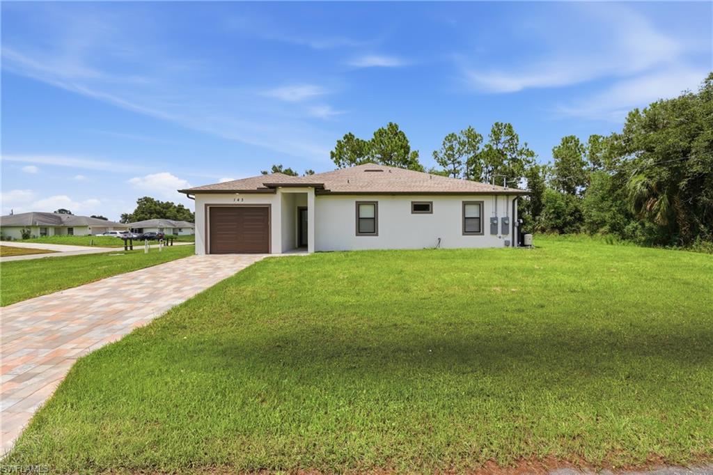 Single-story residence featuring a paver driveway, an attached garage, and a stucco exterior