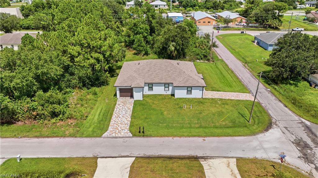 Single-story residence featuring a paved driveway, attached garage, and a shingle roof