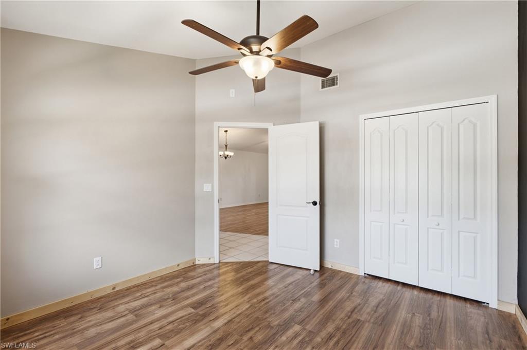 Wood-finish flooring, ceiling fan with integrated lighting, bi-fold closet doors, and light neutral wall colors