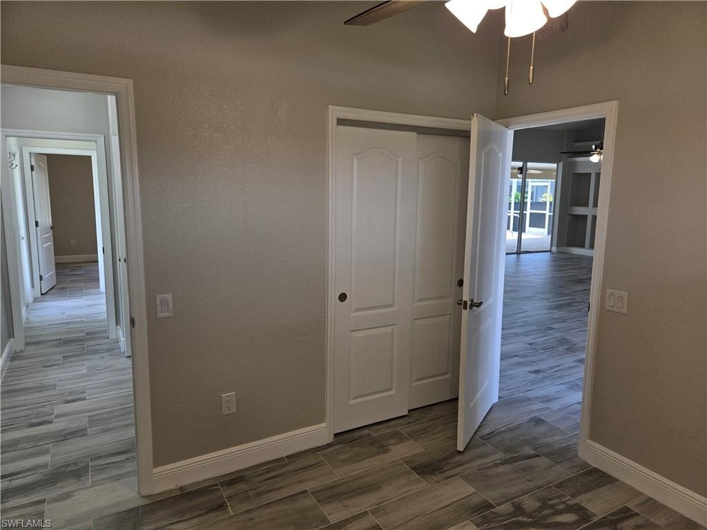 Empty room with a ceiling fan and wood tiled floors