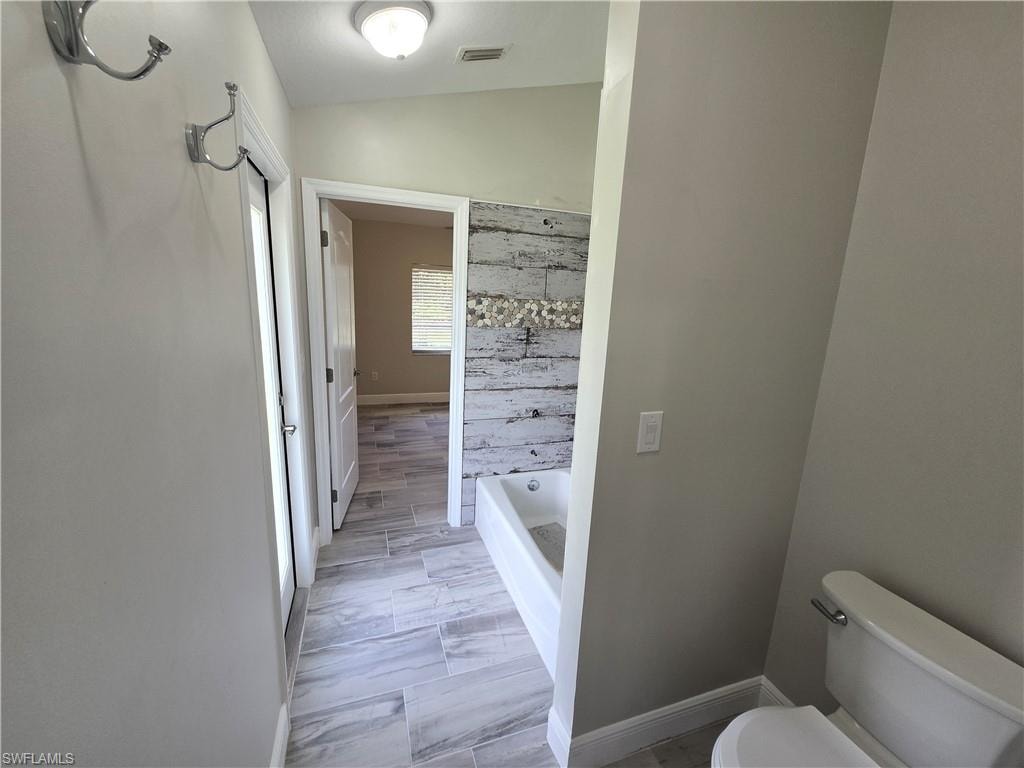 Bathroom with a bathtub and vaulted ceiling
