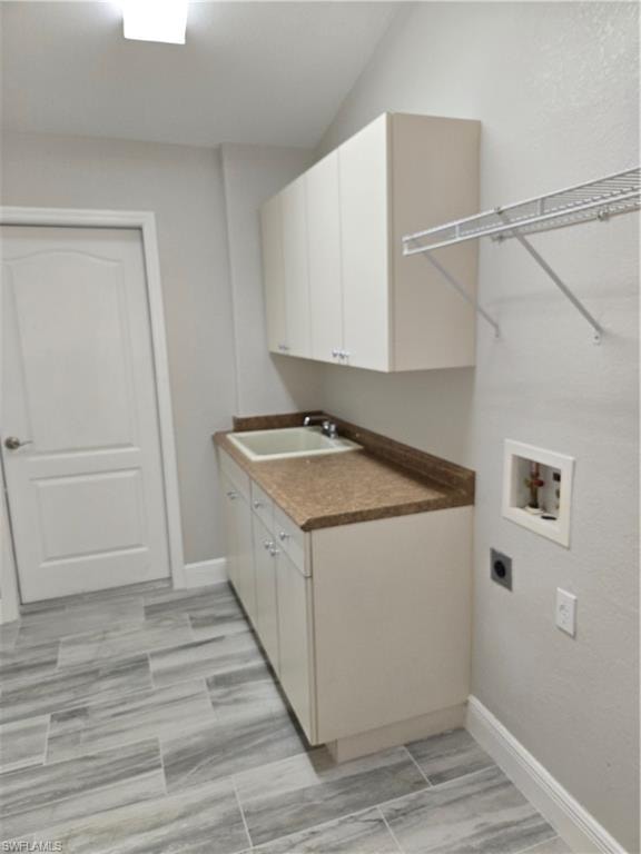Washroom featuring hookup for an electric dryer, washer hookup, and cabinet space