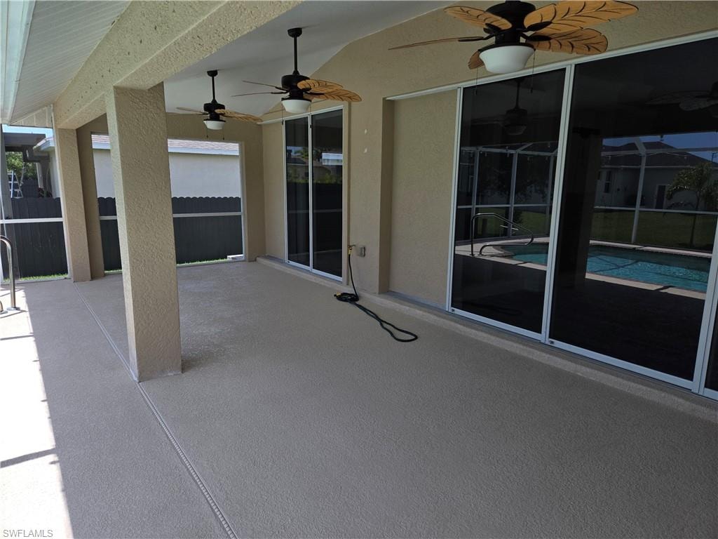 View of patio / terrace featuring a ceiling fan, an outdoor pool, and glass enclosure