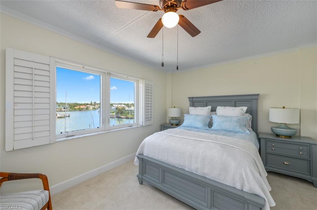 Large window with water scenery and white plantation shutters