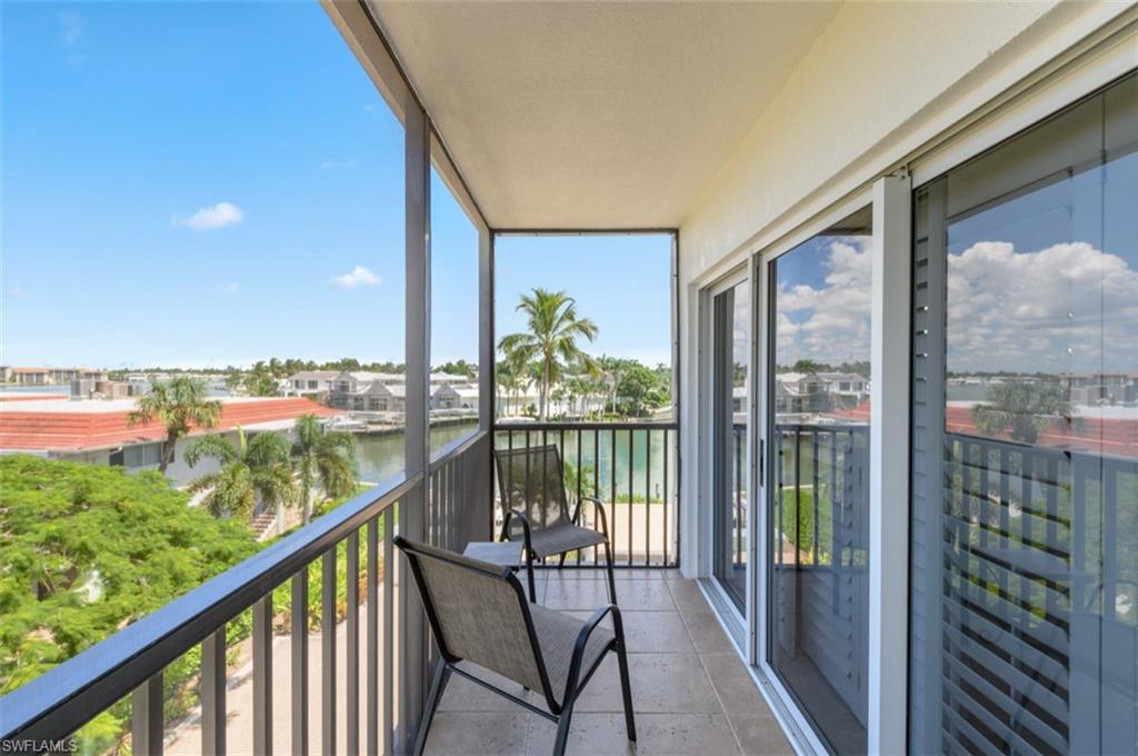 Balcony featuring a tile floor, dark metal railing, and sliding glass doors