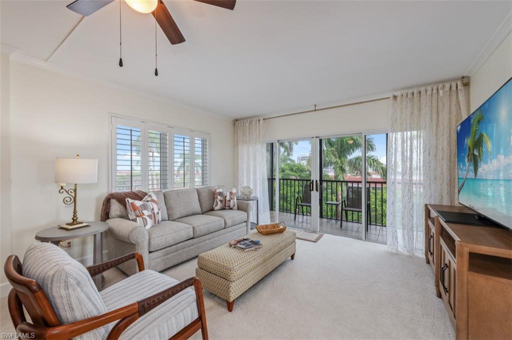 Recessed lighting, ceiling fan, crown molding, plantation shutters, and sliding glass doors to balcony