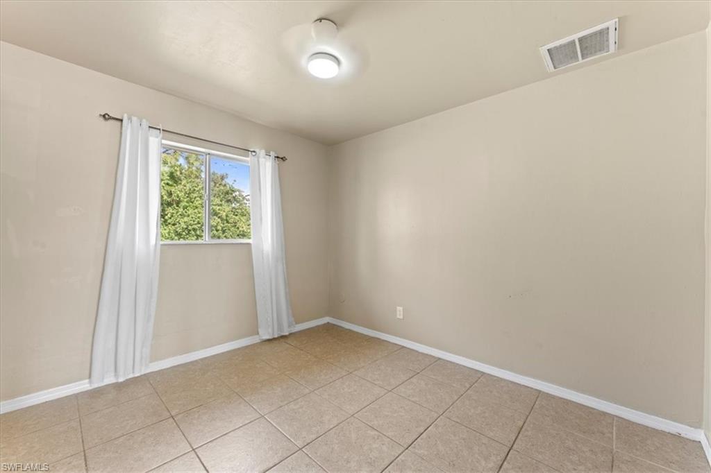 Spare room featuring visible vents, baseboards, and light tile patterned flooring