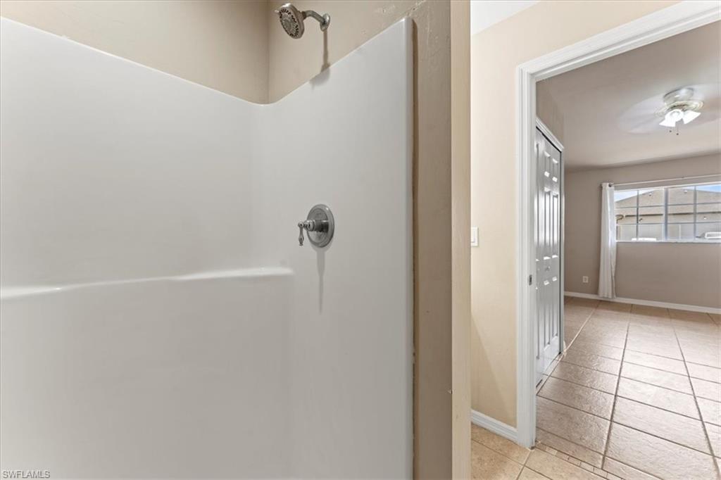 Full bathroom with tile patterned flooring, baseboards, and walk in shower