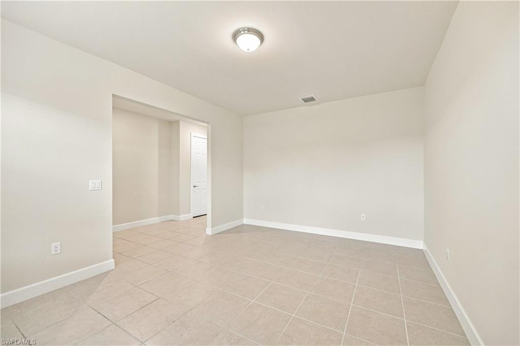 Ceramic tile flooring, neutral wall tones, recessed lighting, and a white interior door