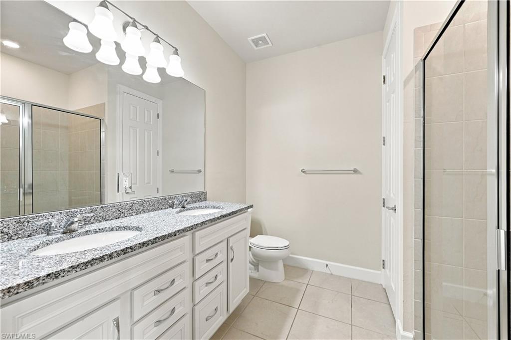Dual vanity with stone countertop, twin undermount sinks, and white shaker-style cabinetry