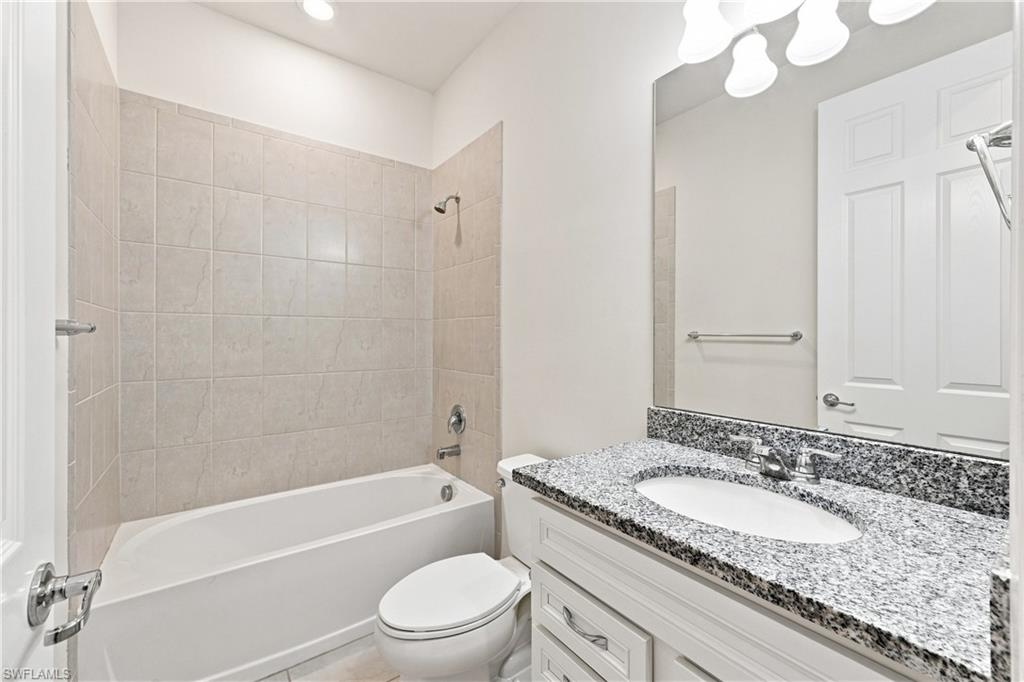 Spa-inspired bathroom featuring a white vanity with ample storage, speckled stone countertop, and an undermount sink
