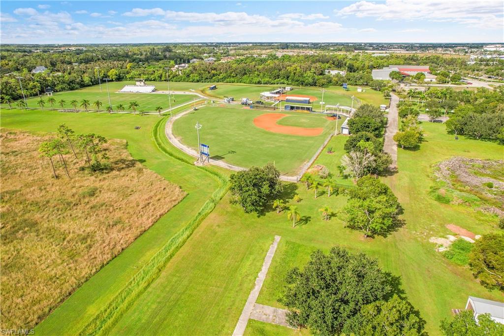 Expansive recreational property featuring a professionally maintained baseball diamond with infield, dugout structures, and outfield fencing