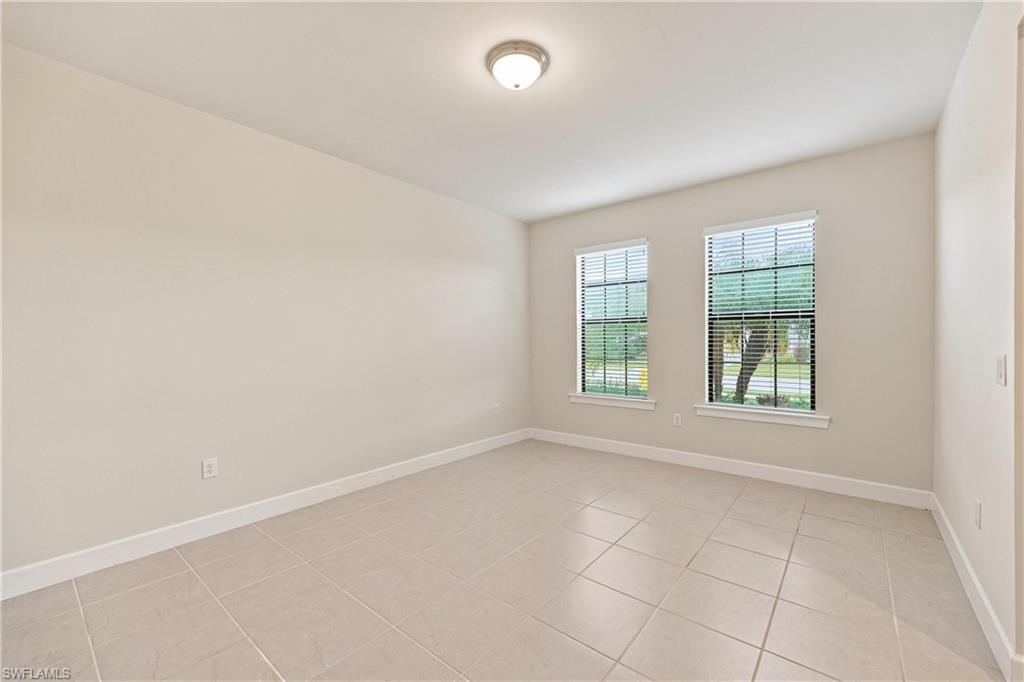 Bright, airy room featuring dual casement windows with gridded panes, neutral wall finishes, and neutral tile flooring
