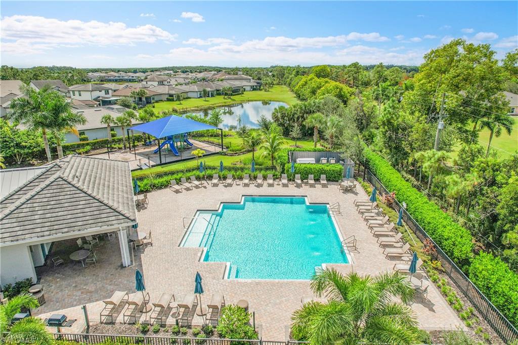 Outdoor swimming pool with integrated steps, surrounding paved deck, and shaded lounge seating