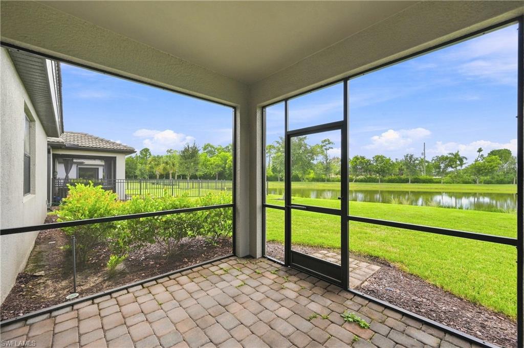 Screened lanai with paver flooring overlooking expansive manicured grounds and pastoral landscape