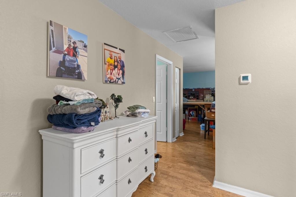 Wood-finish flooring throughout the hallway and into the adjacent room