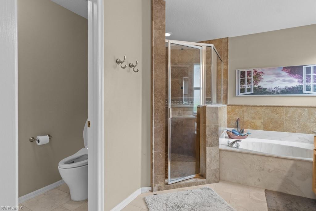 Walk-in shower with glass enclosure, deep soaking tub, and tile surround