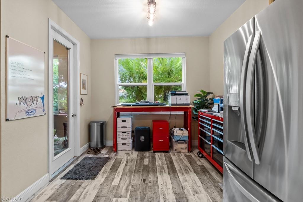 Wood-finish flooring, recessed lighting, and a full-light glass door