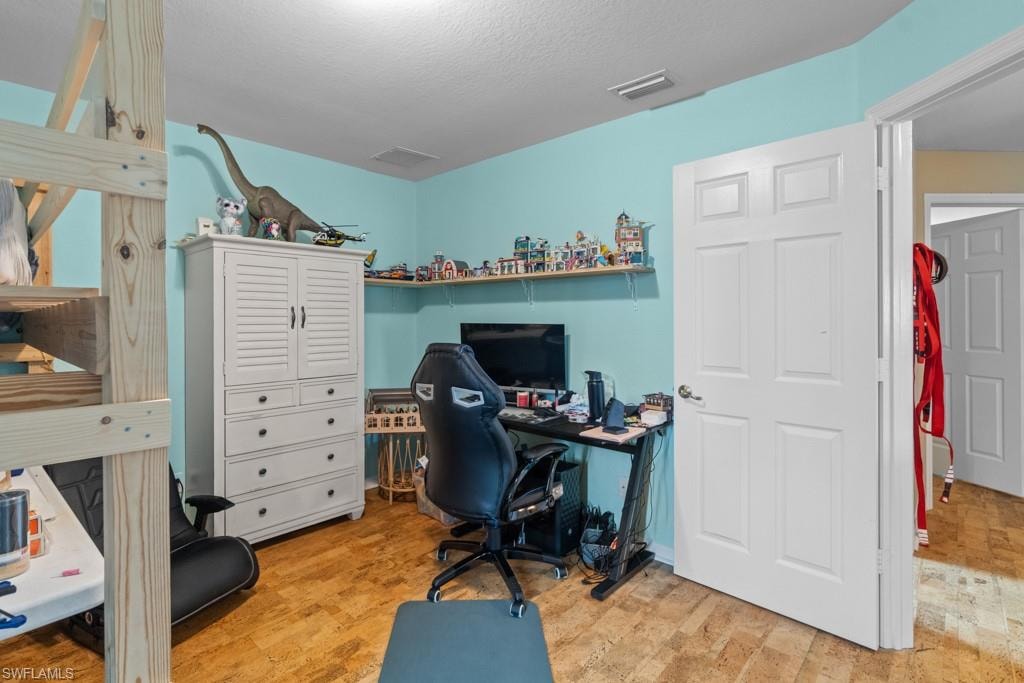 Wood-finish flooring with light blue wall paint, a six-panel interior door, and a built-in corner shelf