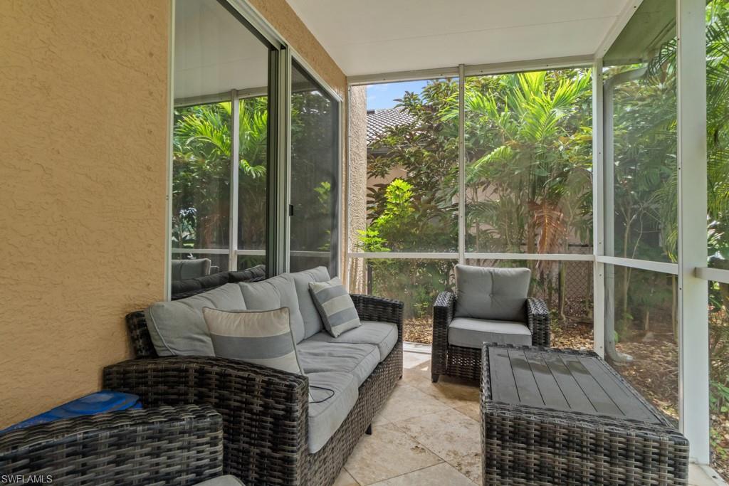 Screened patio featuring a textured exterior wall, sliding glass doors, and a tile floor