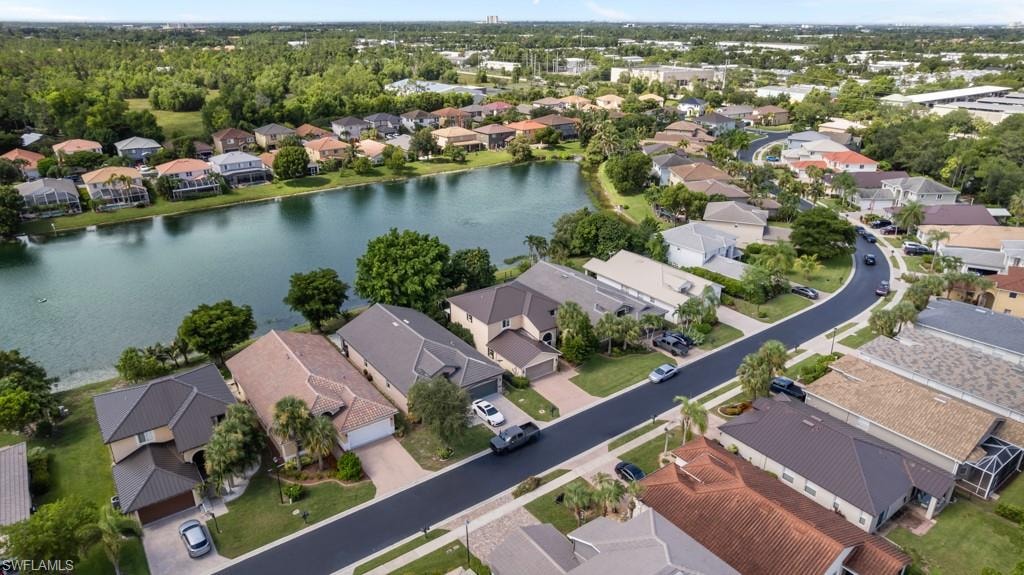 Lakeside community featuring a winding street, mature landscaping, and single-family residences
