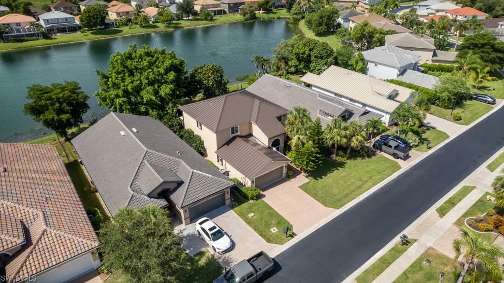 Waterfront property with mature landscaping and a paver driveway