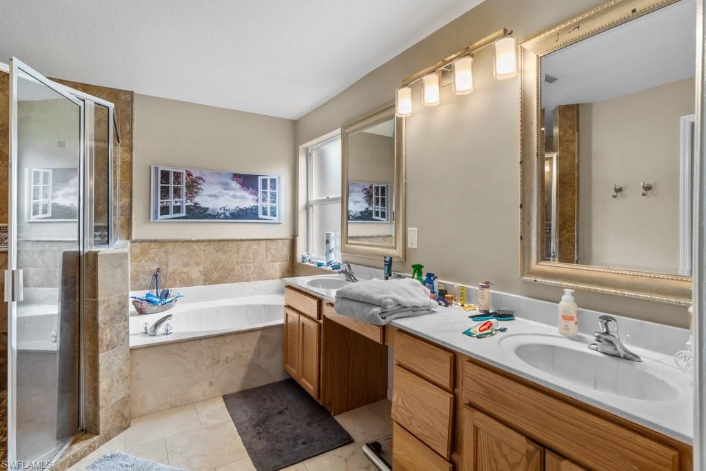 Spa-inspired master bath featuring dual vanities with white countertops, wood cabinetry, and polished nickel fixtures
