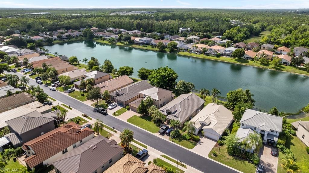 Residential community with a lakefront, surrounded by lush greenery and mature trees