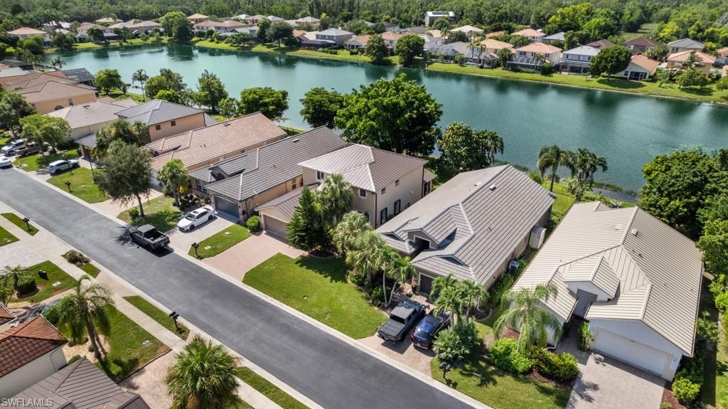 Waterfront property featuring mature landscaping and a well-maintained street