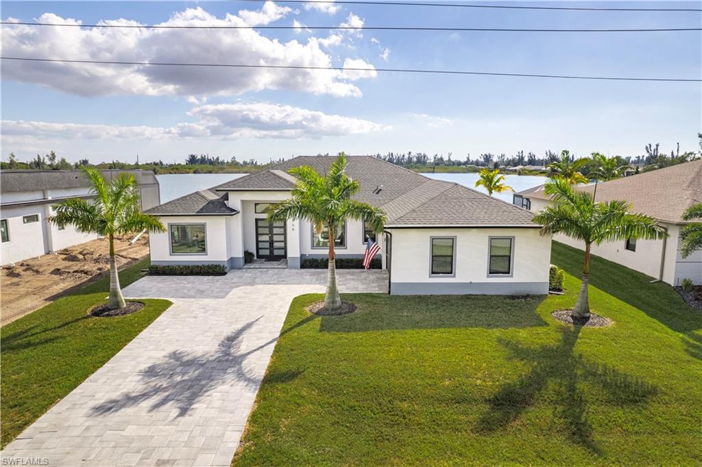 View of front of house with shingle roof, front yard, and stucco siding