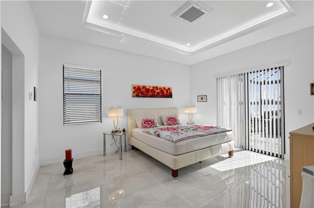 Master bedroom featuring a raised ceiling, access to outside, recessed lighting and mini split AC