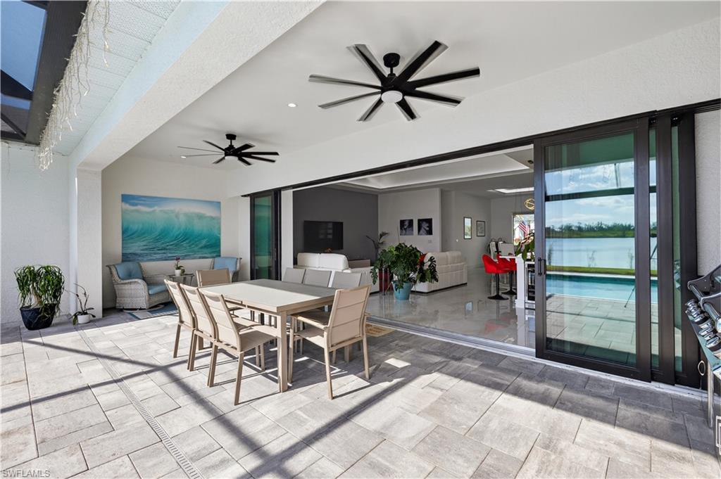 View of patio / terrace with outdoor dining area, a ceiling fan, a water view, and a outdoor kitchen