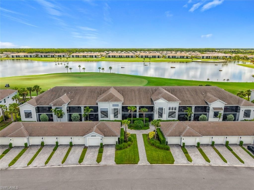 Aerial view of residential area with a golf course and a nearby body of water