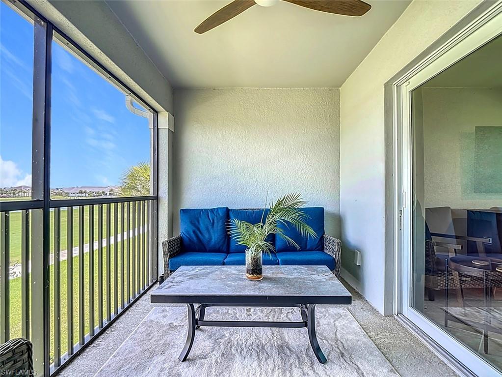 Sunroom with a balcony and a ceiling fan