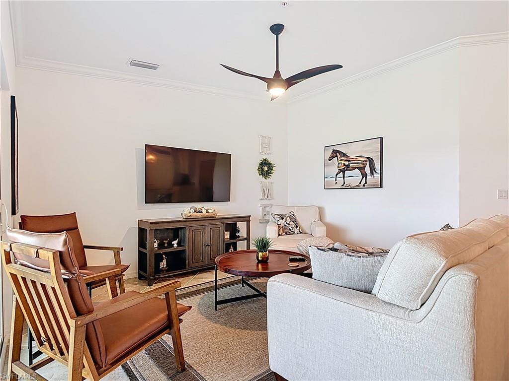 Living area with ornamental molding and ceiling fan