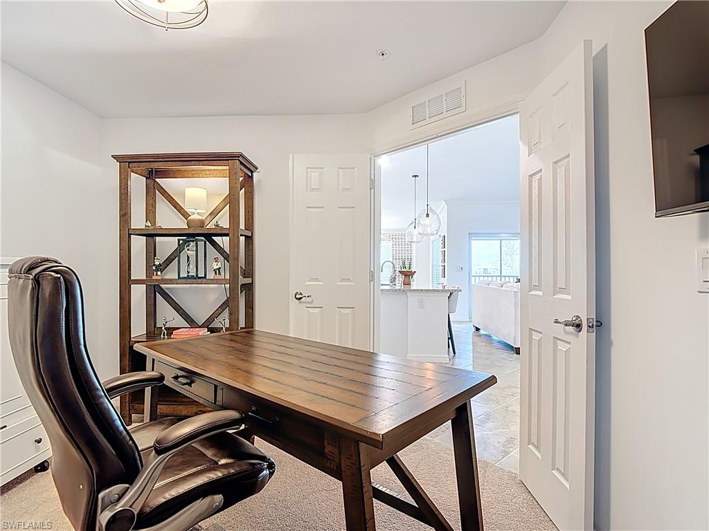 Office featuring light carpet and a chandelier